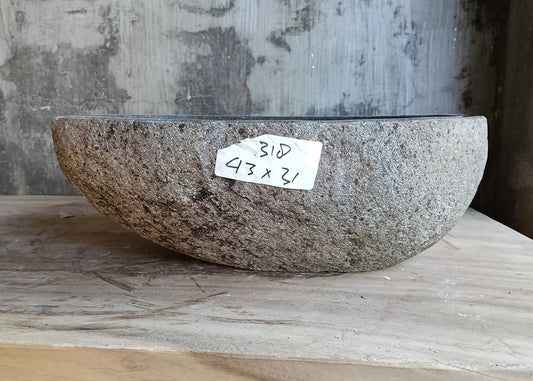 Front view of compact natural stone sink with raw textured surface and curved design
