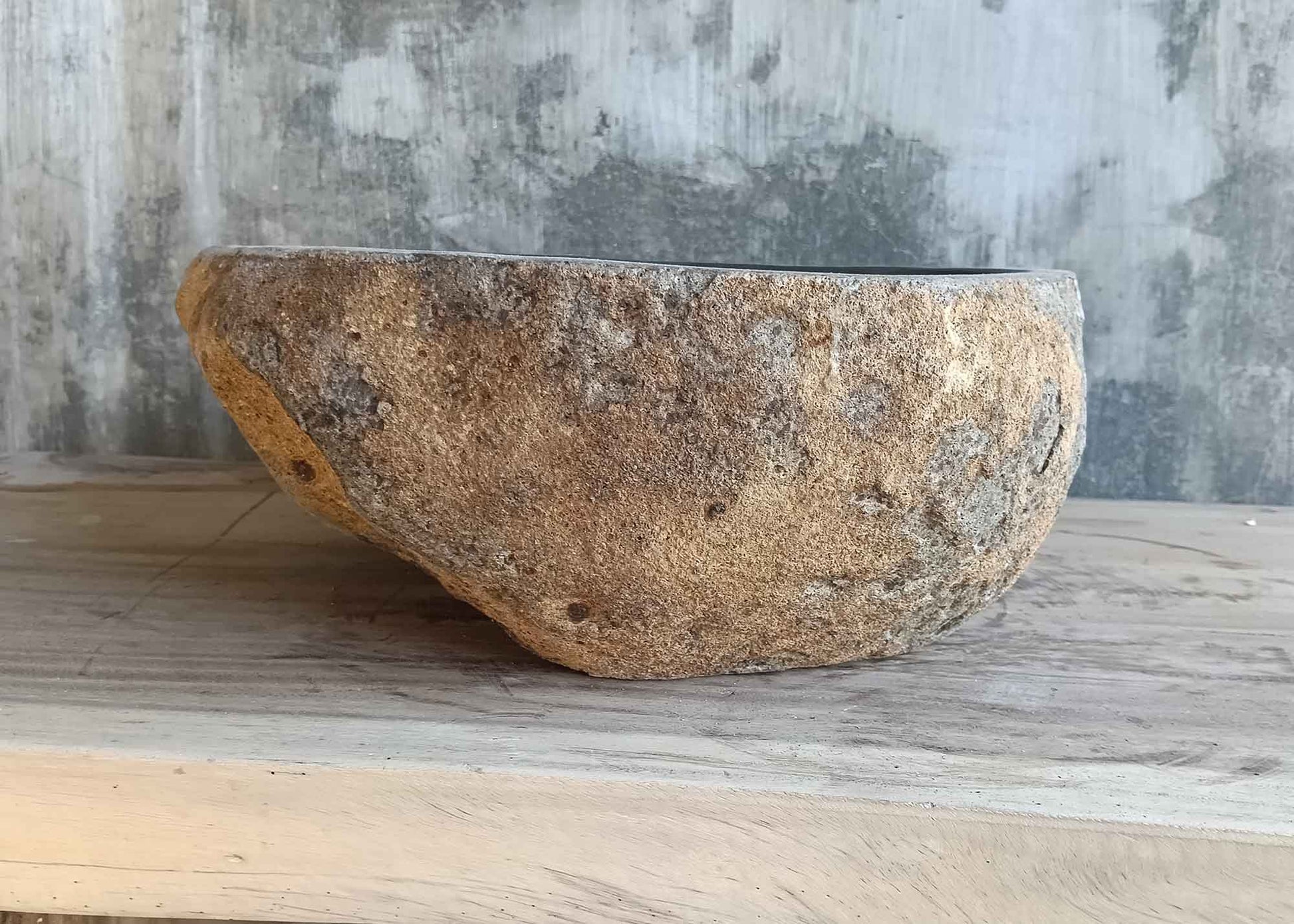Left side view of 14×17 inch dark black river stone sink in irregular shape
