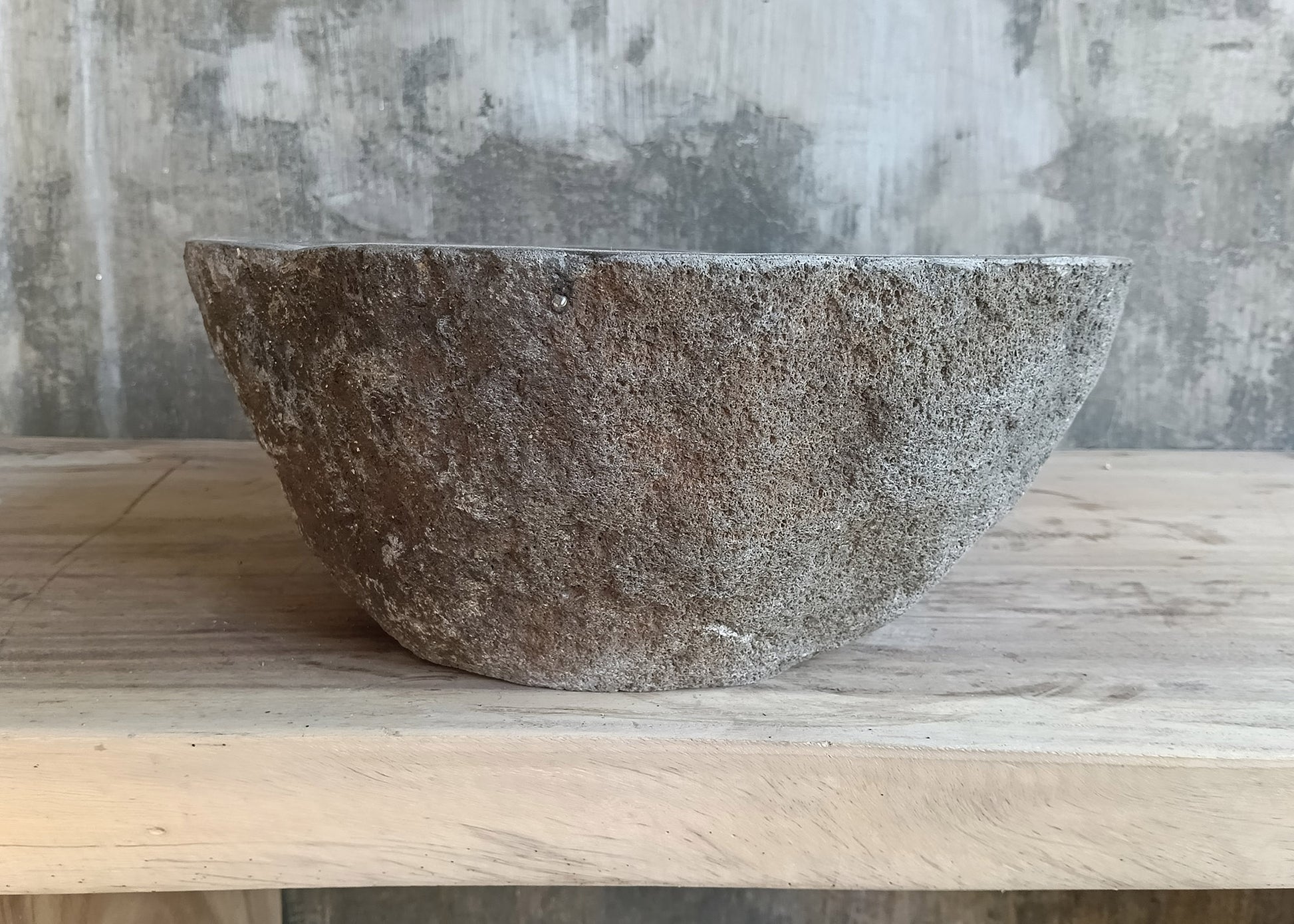 Back of gray stone sink with natural exterior and lightweight profile  

