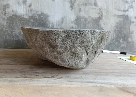 Front view of handcrafted oval sink showing smooth inner surface and raw stone texture  
