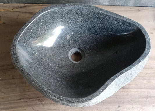 Top view of irregular gray river stone sink with smooth polished interior  
