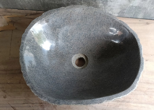Top view of handcrafted gray river stone sink with porous polished surface  
