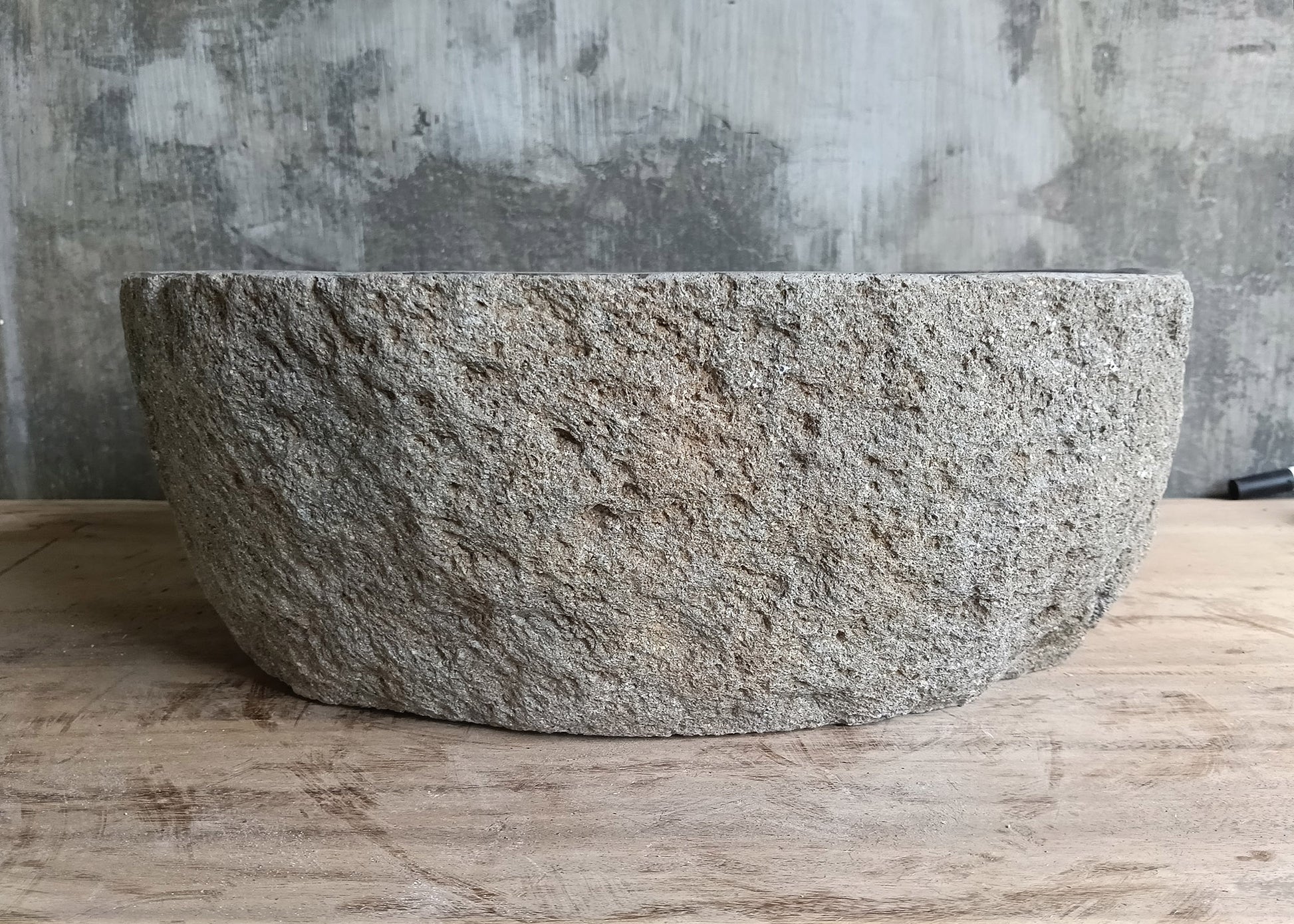 Front of lightweight oval stone sink showing smooth gray texture and boat-like shape  
