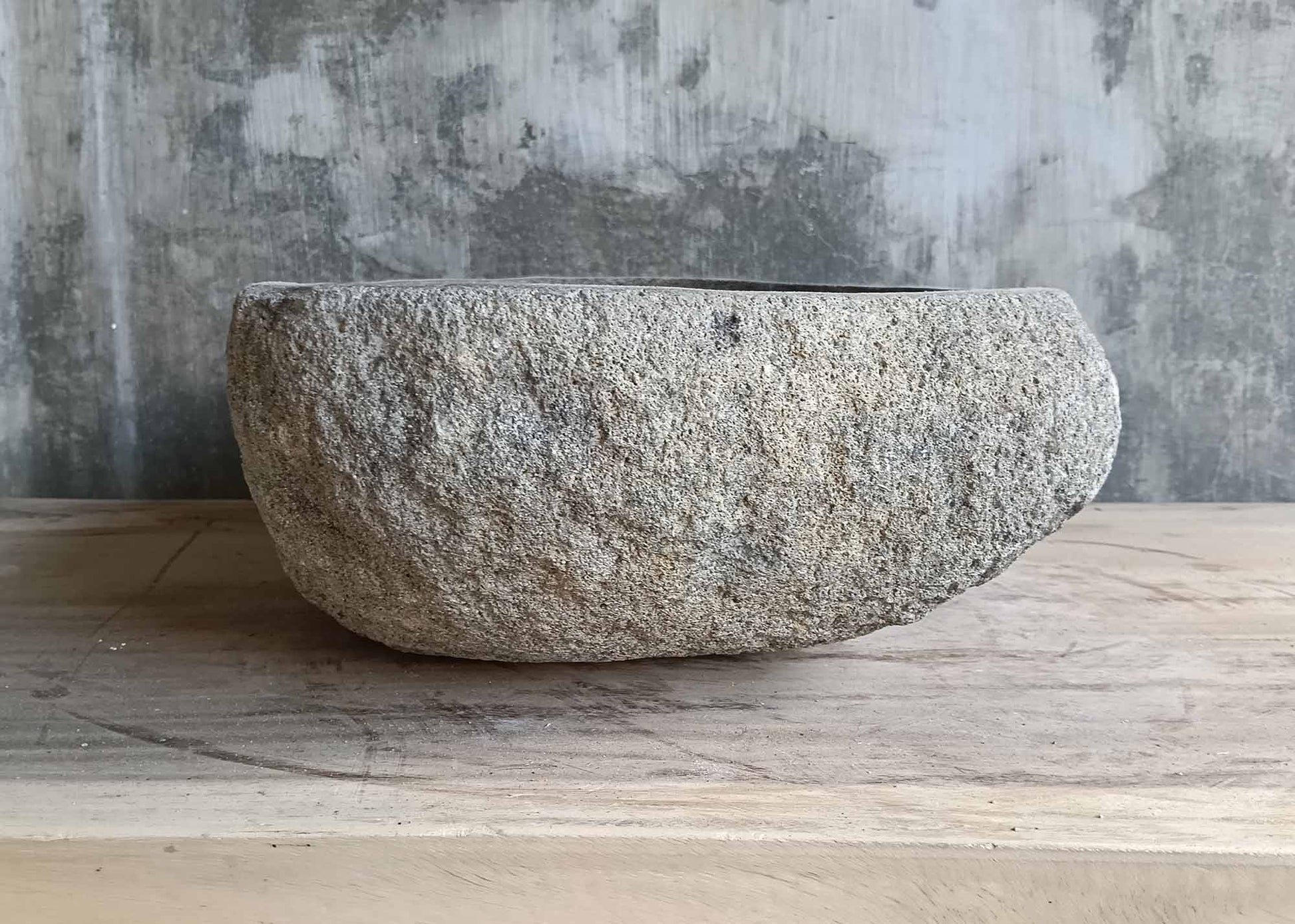 Right angle of teardrop gray basin showing sculpted stone shape and texture  
