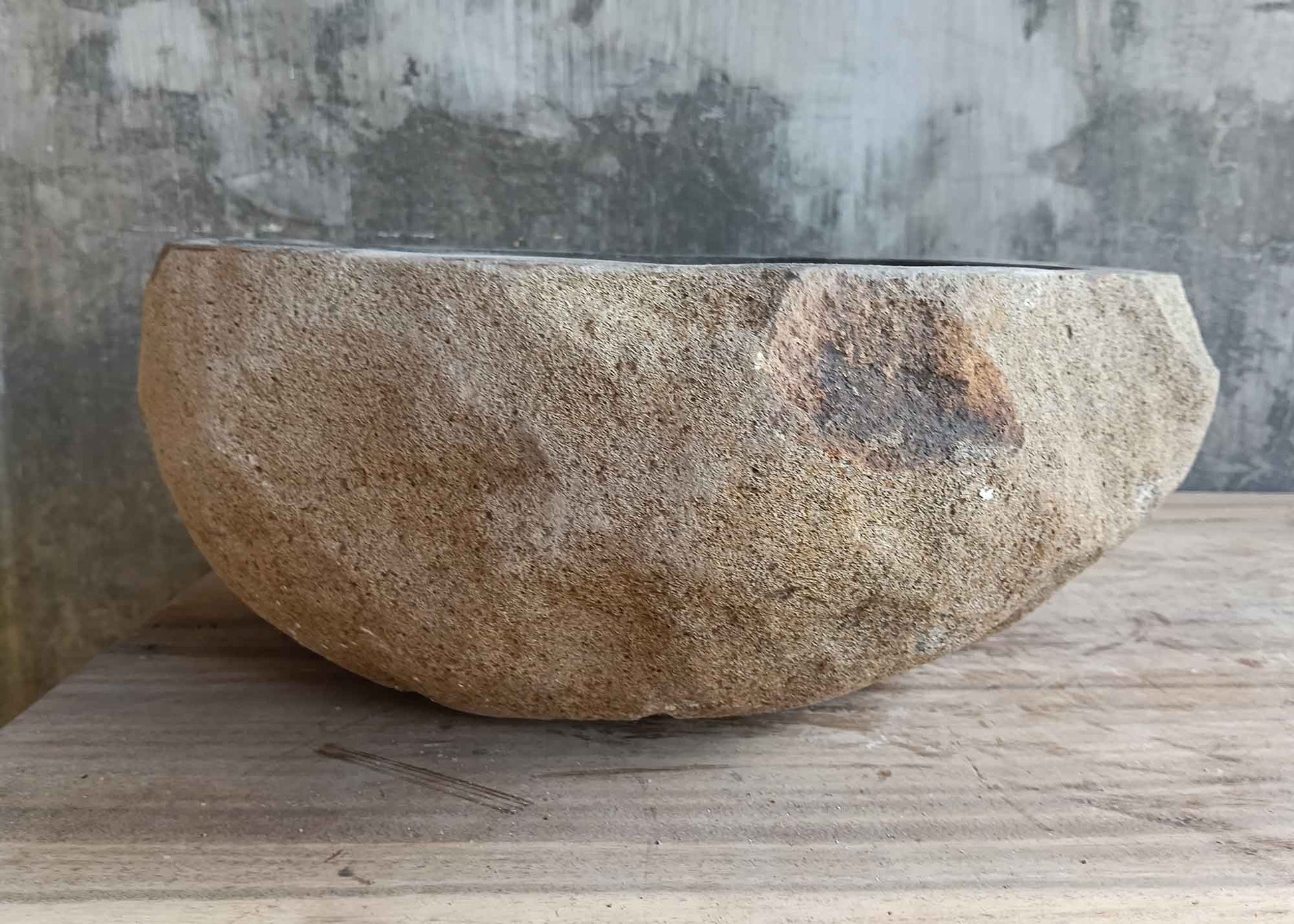 Left side view of 15×14 inch dark gray river stone sink in rounded boat shape
