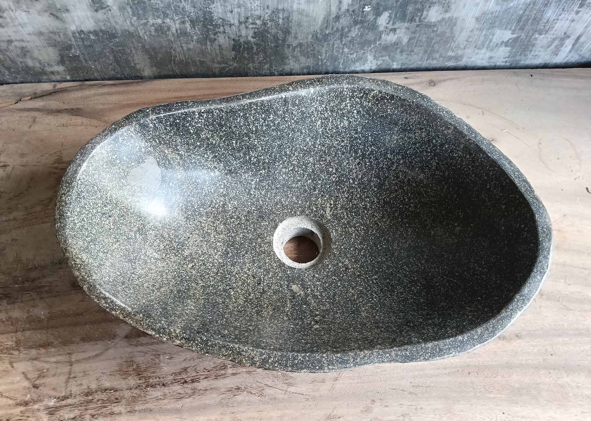 Top view of handcrafted dark gray river stone sink with polished interior  
