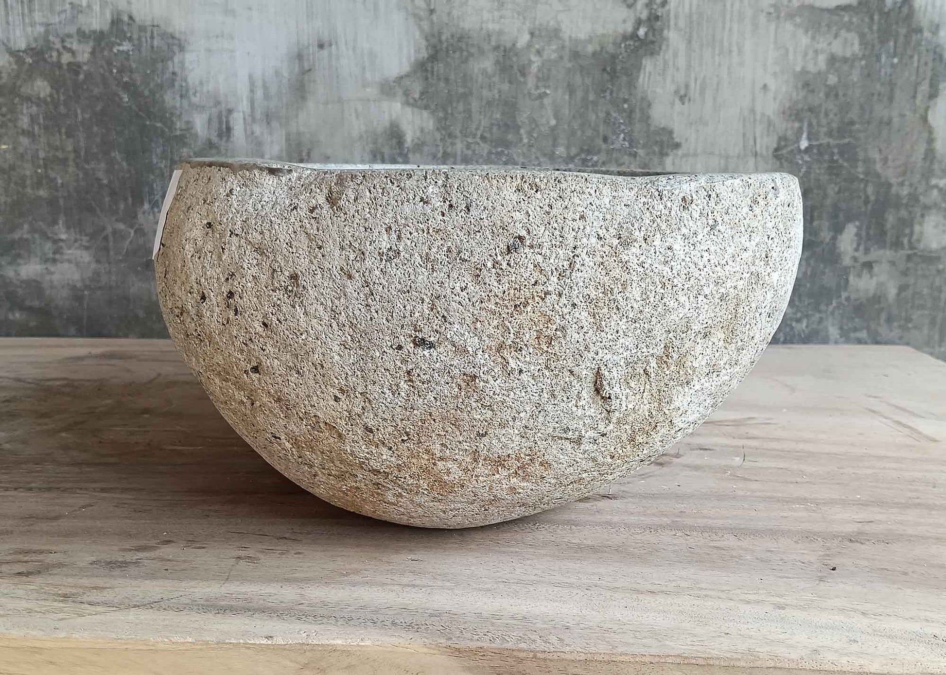 Left side view of 13×11 inch light river stone sink with smooth round form
