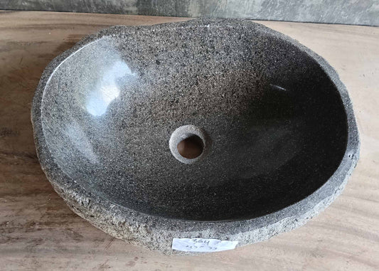 Top view of handcrafted gray river stone sink with soft oval shape and polished interior  
