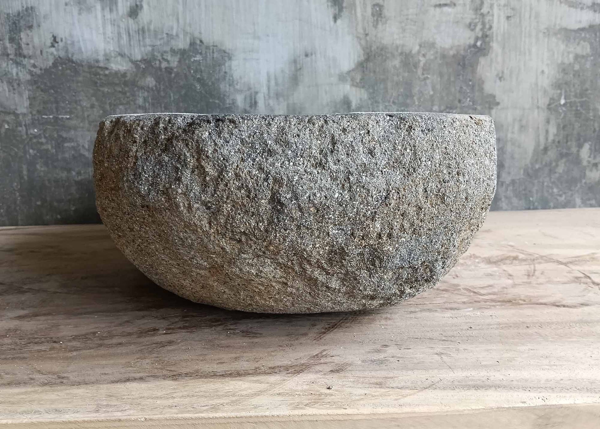 Right side of handcrafted river stone sink with soft asymmetry and rustic texture  
