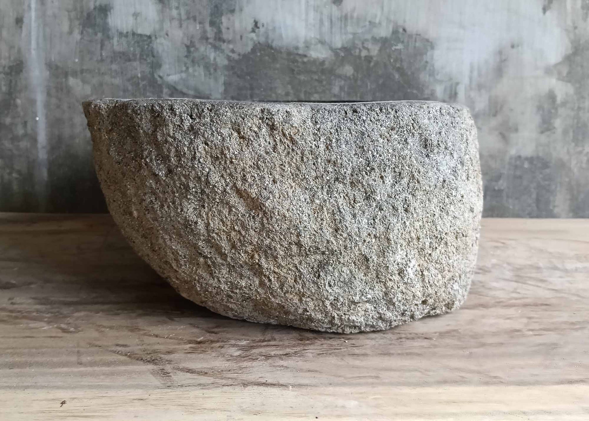 Left side of oval river basin showing rough porous finish and curved shape  
