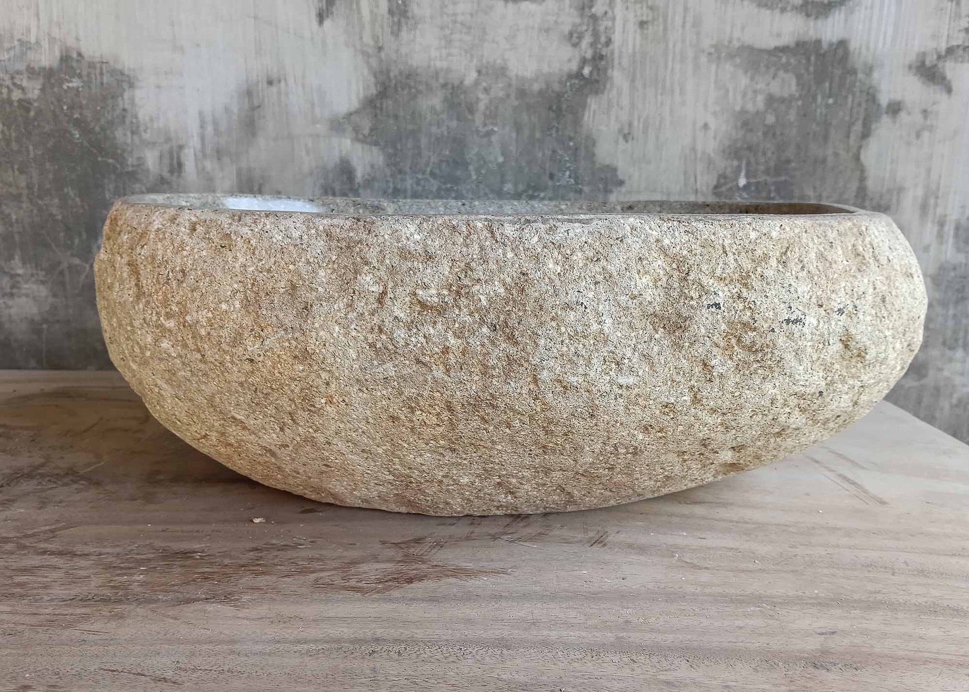 Side view of handcrafted river stone sink with beige textured finish – 6367


