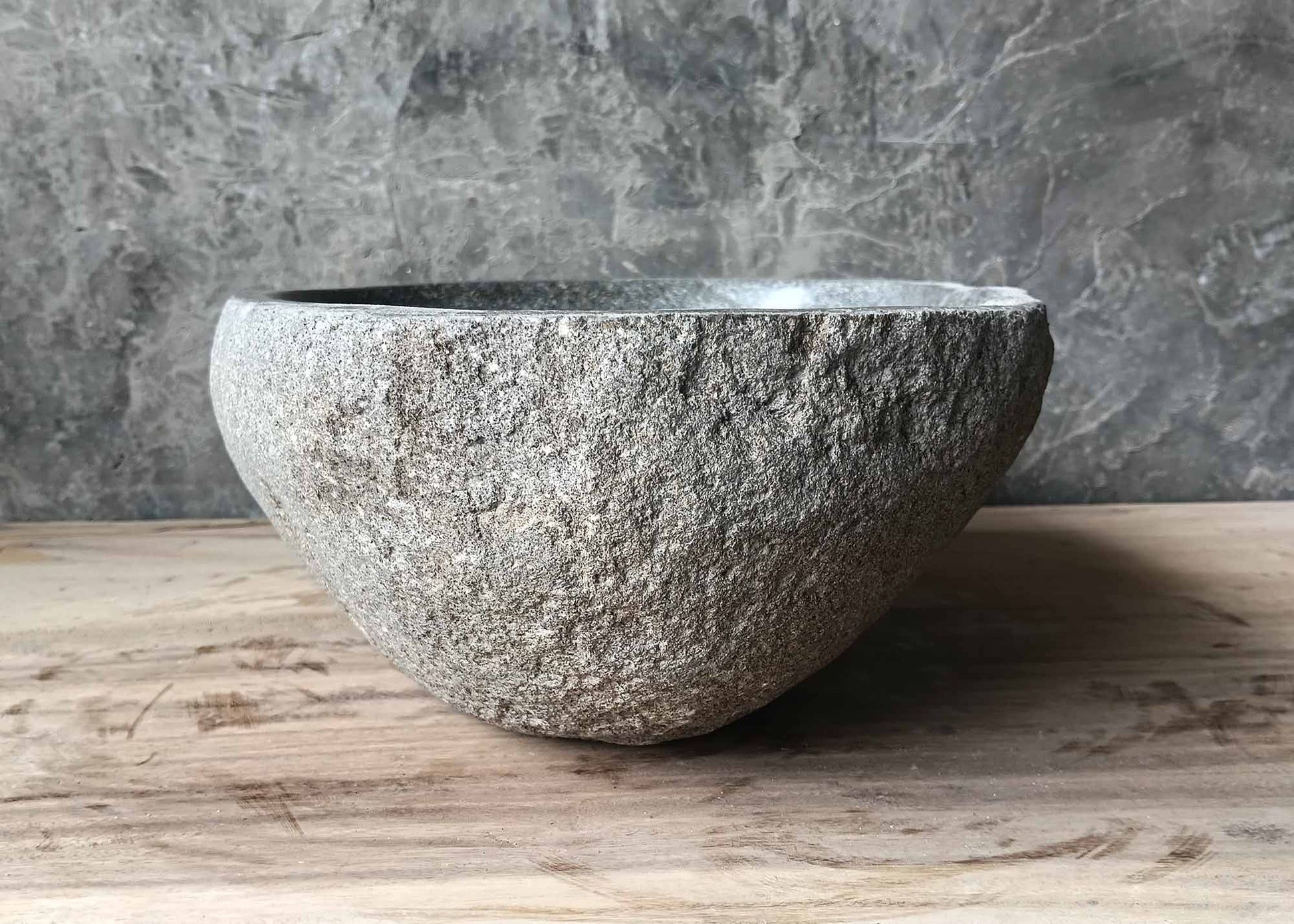 Left edge of river stone basin with natural light gray stone finish
