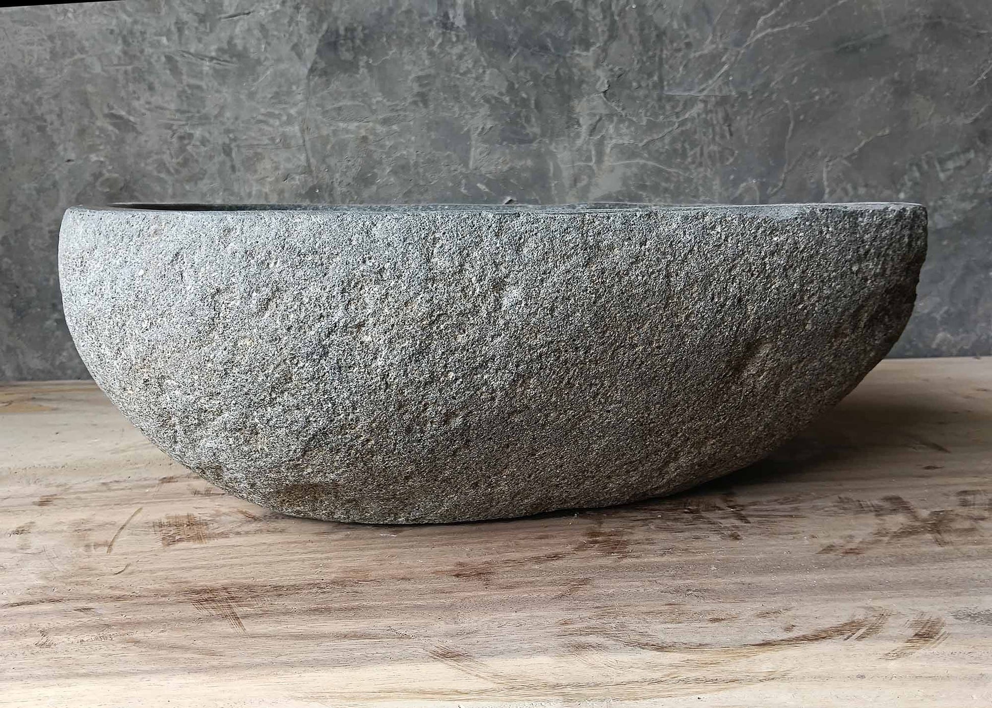 Front profile of light gray river stone sink with smooth oval shape
