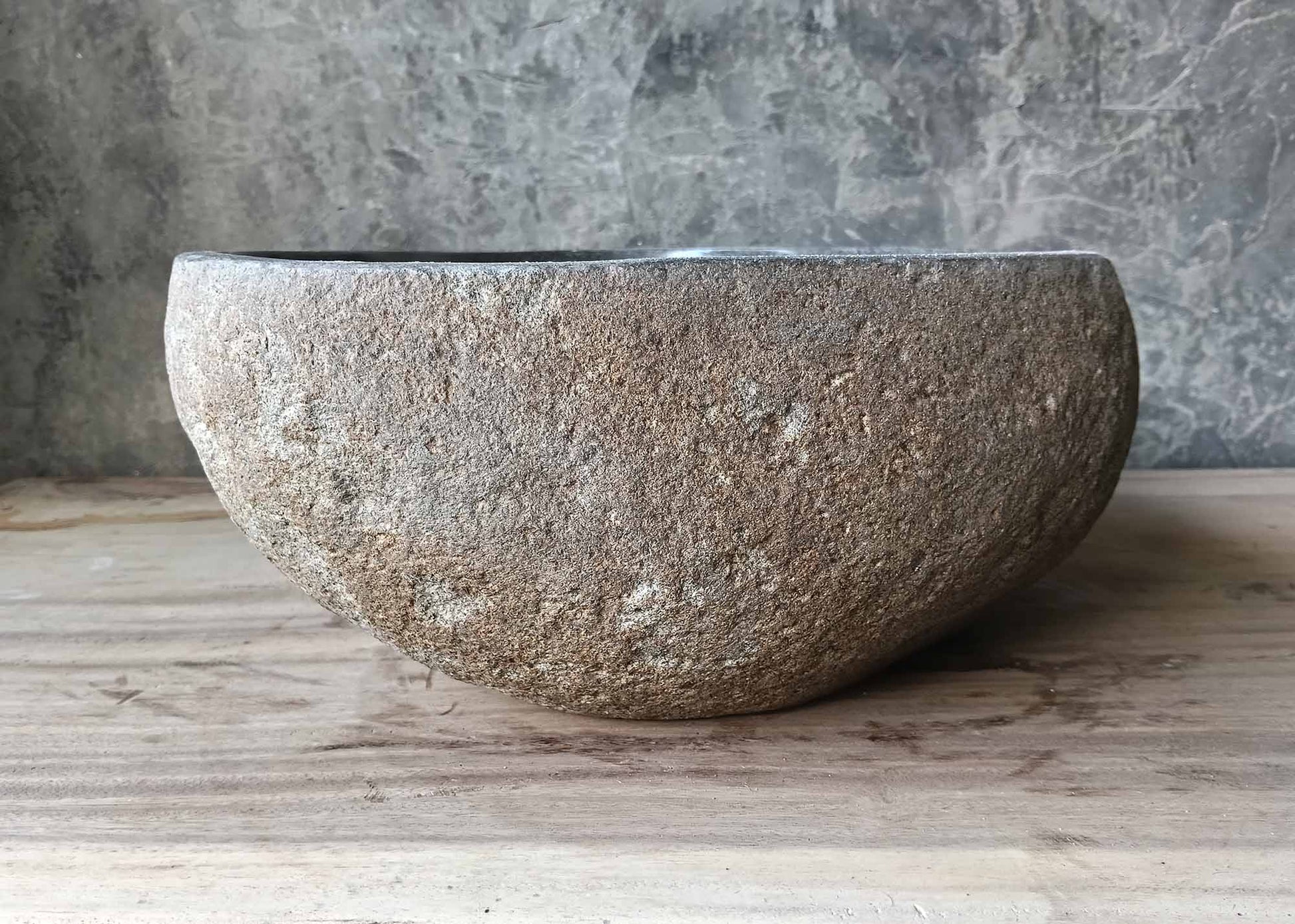 Side angle showing rustic stone texture and smooth upper edge of the sink
