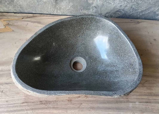 Front view of handcrafted river stone sink with natural textured brown-gray exterior
