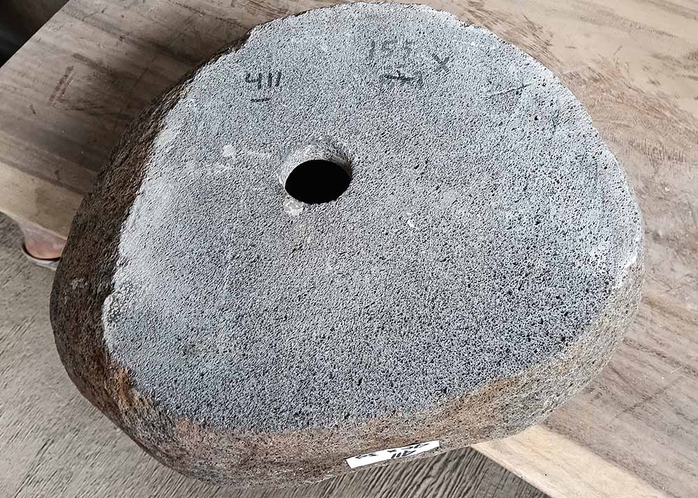 Bottom view of upside-down river stone sink showing centered drain hole and full stone integrity

