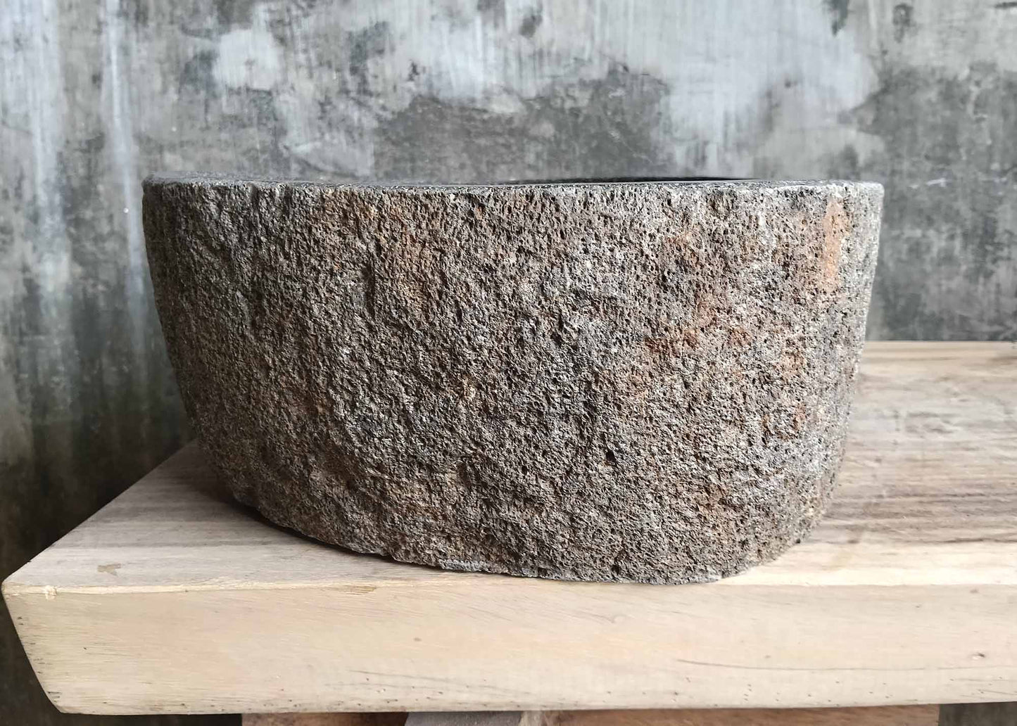 Right-side view of asymmetrical stone sink with coarse pumice-like exterior

