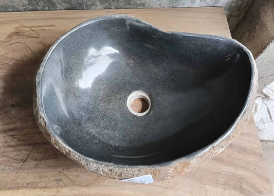 Top view of handcrafted river stone sink with deep polished black basin

