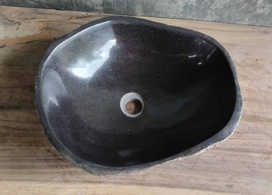 Top view of black river stone sink with polished asymmetrical basin
