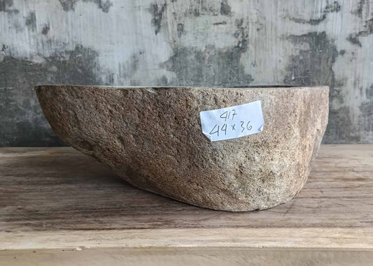 Front profile of slanted river stone sink in sandy beige tones
