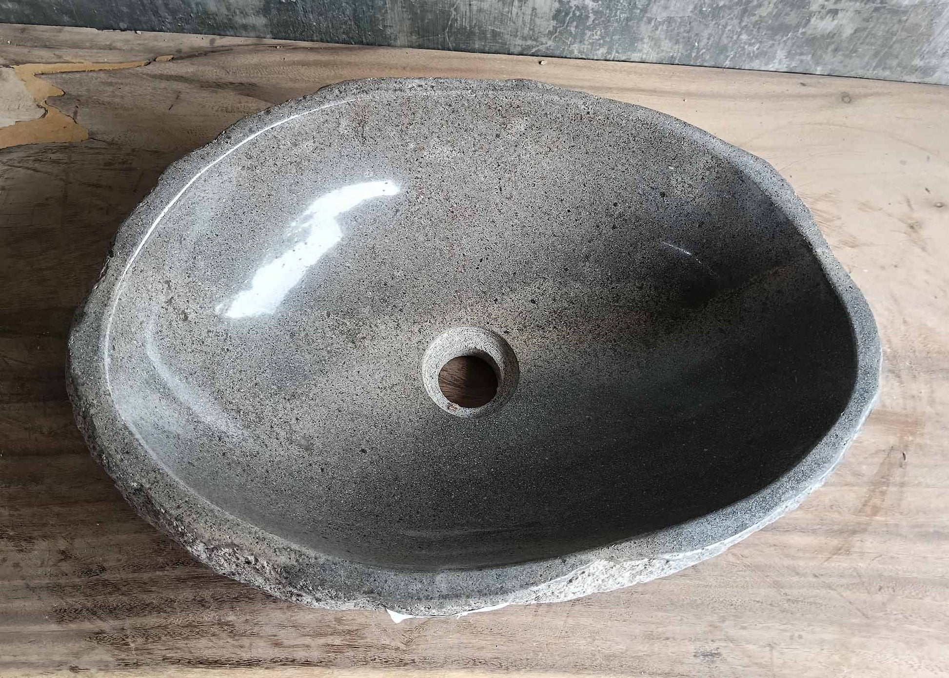 Top view of a handcrafted river stone sink with smooth grey polished interior and natural edges
