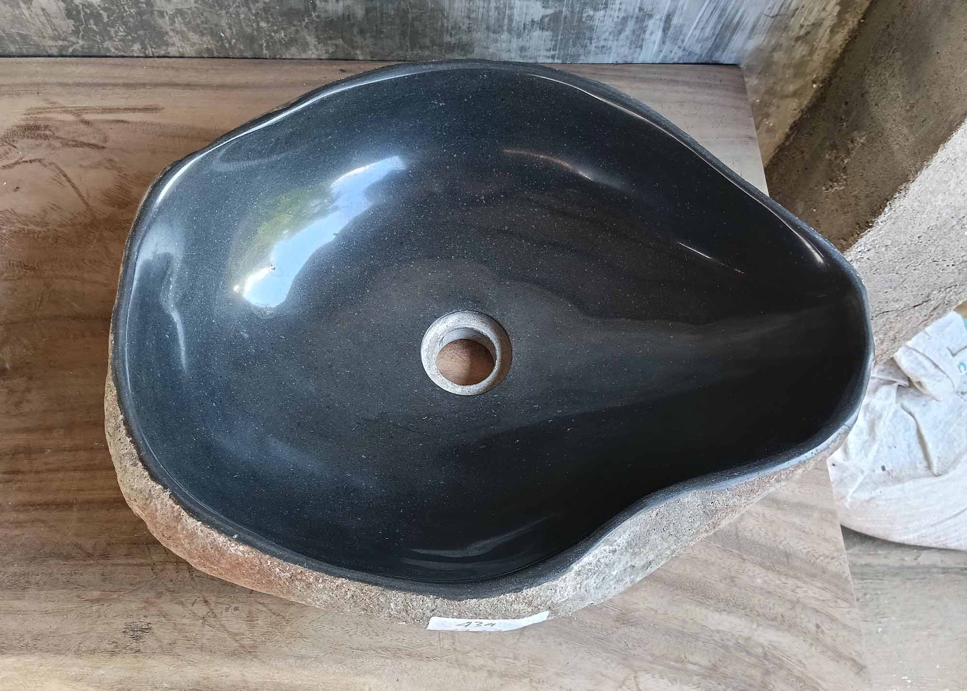 River stone sink with deep black polished interior and asymmetrical organic shape – top view
