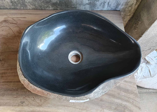 River stone sink with deep black polished interior and asymmetrical organic shape – top view
