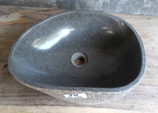 Top view of a handcrafted river stone sink with soft gray interior and oval shape
