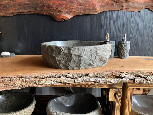 Gray andesite stone vessel sink ANS-001 with a polished oval basin on a live edge wood countertop