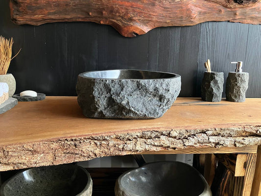 Compact triangular andesite stone vessel sink ANS-007 with a rich black interior, viewed from above