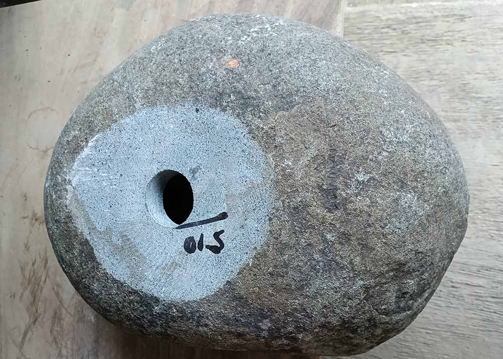 Bottom of river stone sink 6510-4030 with rough base and centered drain hole
