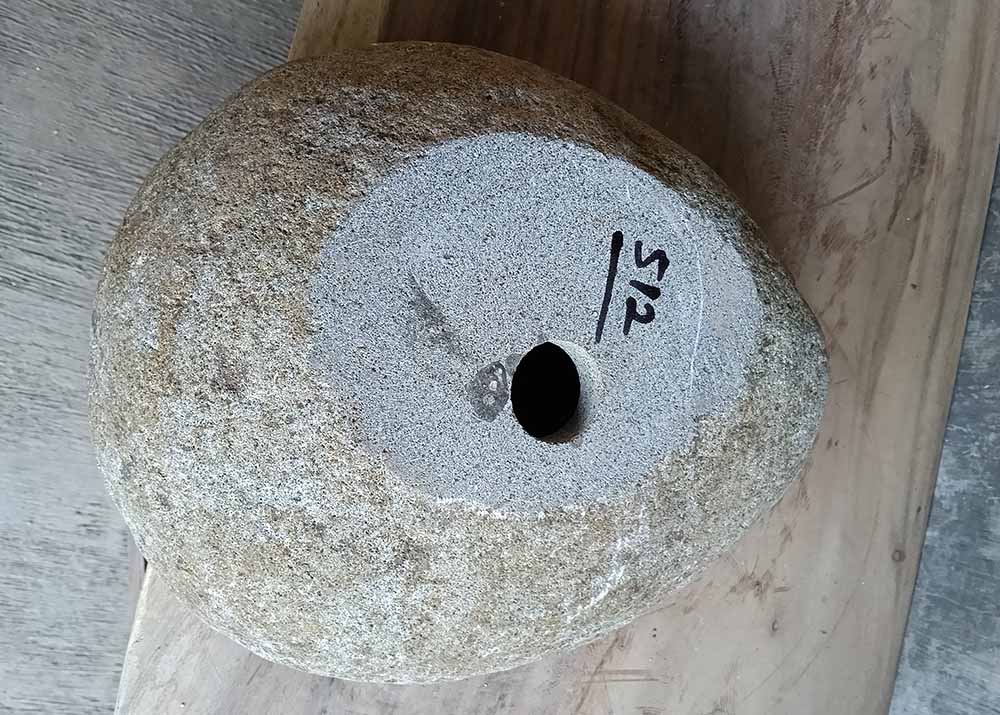 Underside of river stone sink 6512-4133 with natural base and centered drain
