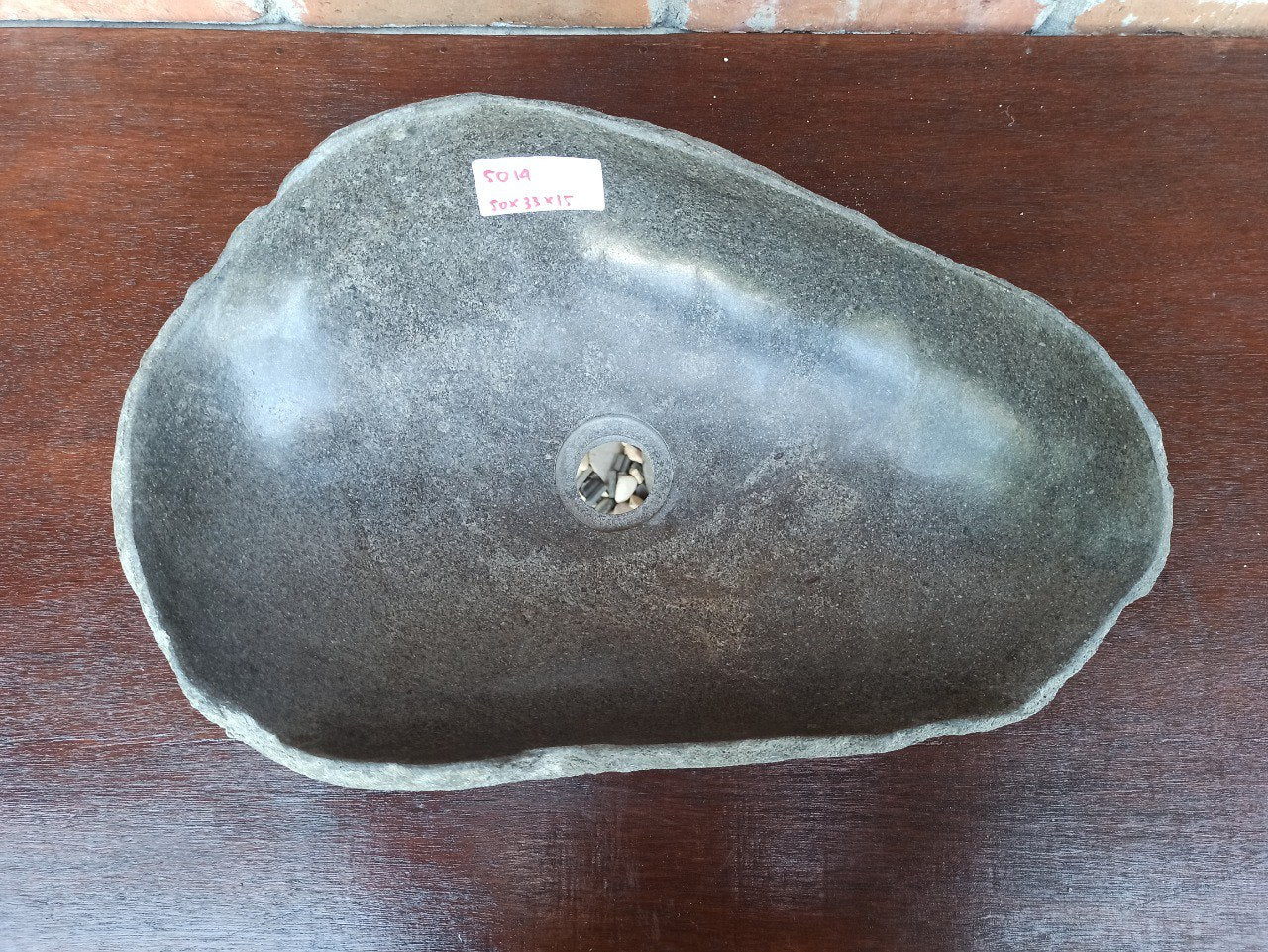 Top view of 5014-5033 elongated river stone sink — polished dark interior and natural rough edge
