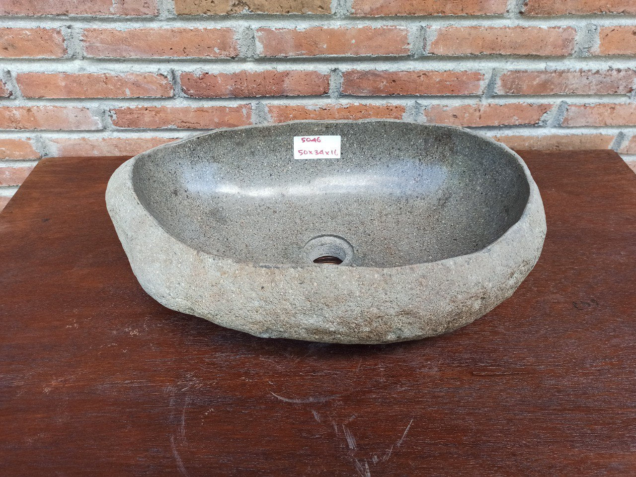 Top view of 5046-503416 oval river stone sink — polished dark interior and textured stone exterior
