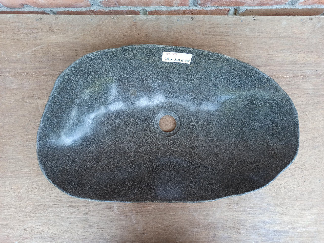 Top view of 5158-5434 elongated river stone sink — polished dark interior and rough stone exterior
