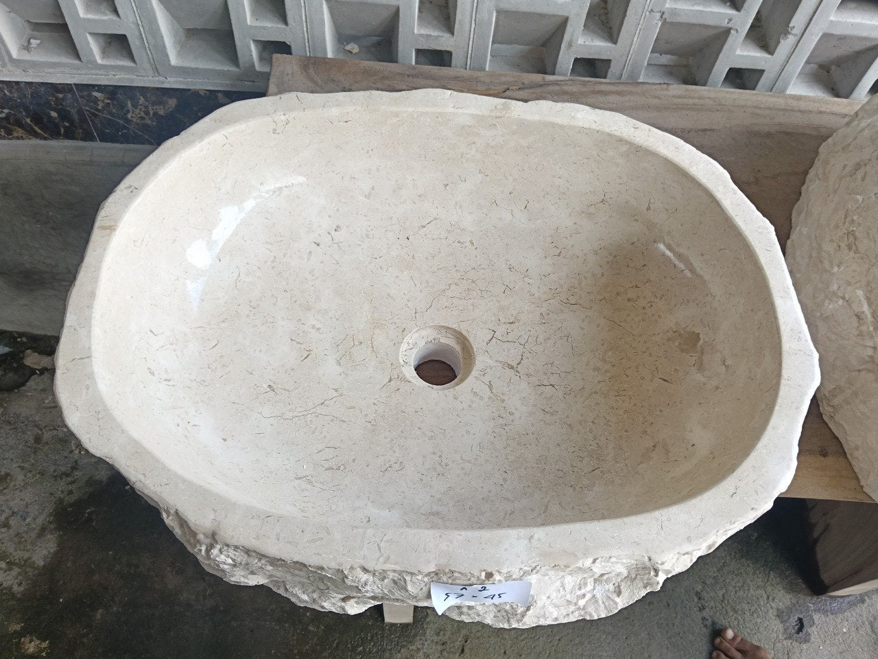 Top view of A2-5745 cream–beige marble sink with polished interior and natural rough exterior, elongated organic oval shape.
