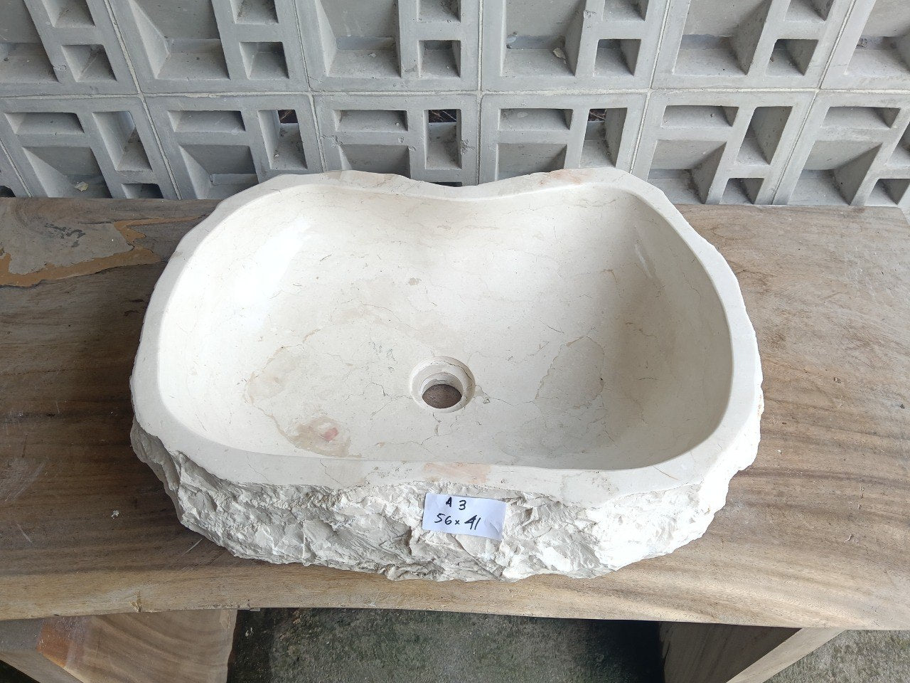 Top view of A3-5641 cream–ivory marble sink with polished interior and rough natural exterior, organic oval-rectangular shape.
