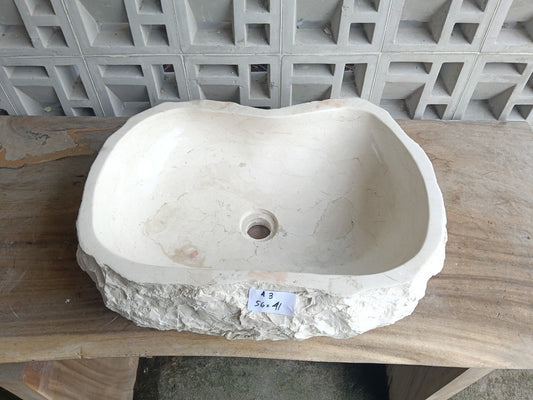 Top view of A3-5641 cream–ivory marble sink with polished interior and rough natural exterior, organic oval-rectangular shape.
