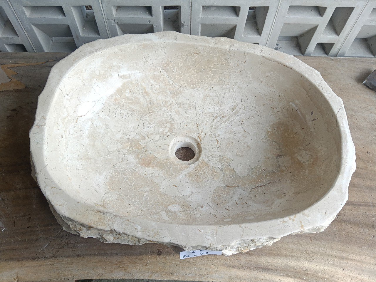 Top view of A5-5643 cream-beige marble sink with polished interior and rough natural exterior, elongated organic oval shape.
