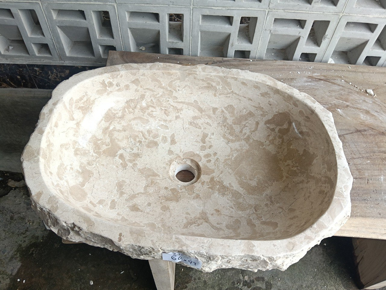 Top view of A11-6043 cream–beige marble sink with polished interior and rough natural exterior, elongated organic oval shape.
