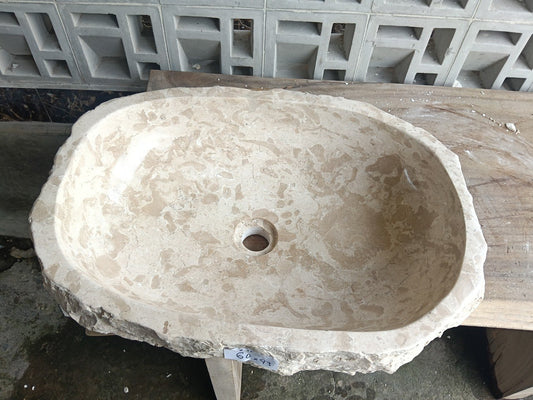 Top view of A11-6043 cream–beige marble sink with polished interior and rough natural exterior, elongated organic oval shape.
