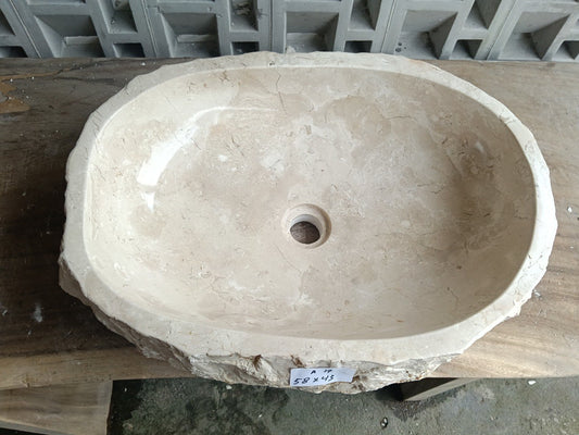 Top view of A17-5843 cream–beige marble sink with polished interior and rough natural exterior, elongated organic oval shape.
