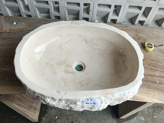 Top view of A18-6045 cream-white marble sink with polished interior and rough natural exterior, elongated organic oval shape.
