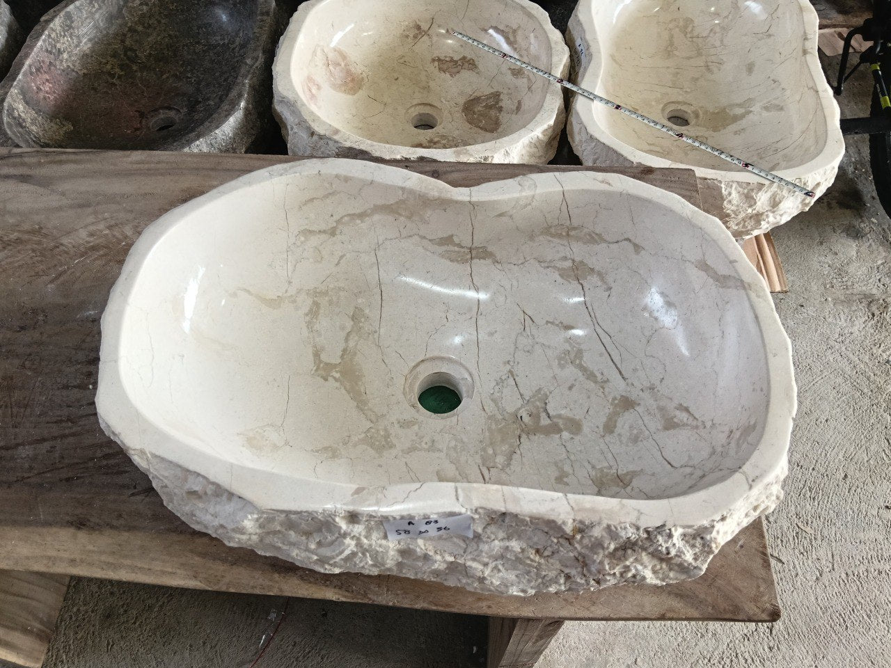 Top view of A83-5836 white–cream marble sink with polished interior and rough natural exterior, elongated organic oval shape.
