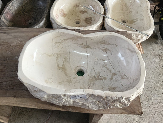 Top view of A83-5836 white–cream marble sink with polished interior and rough natural exterior, elongated organic oval shape.
