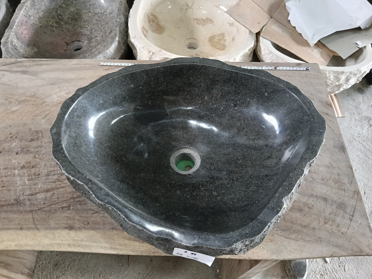 Top view of A94-5242 black andesite stone sink with polished interior and rough chiseled exterior, organic oval irregular shape.
