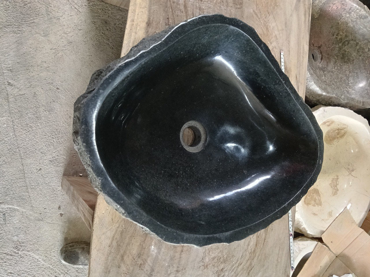 Top view of A95-5243 black andesite stone sink with polished interior and rough chiseled exterior, triangular organic shape.

