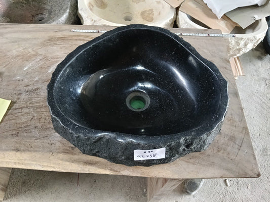 Top view of A96-4238 black andesite stone sink with polished interior and rough chiseled exterior, organic irregular shape.
