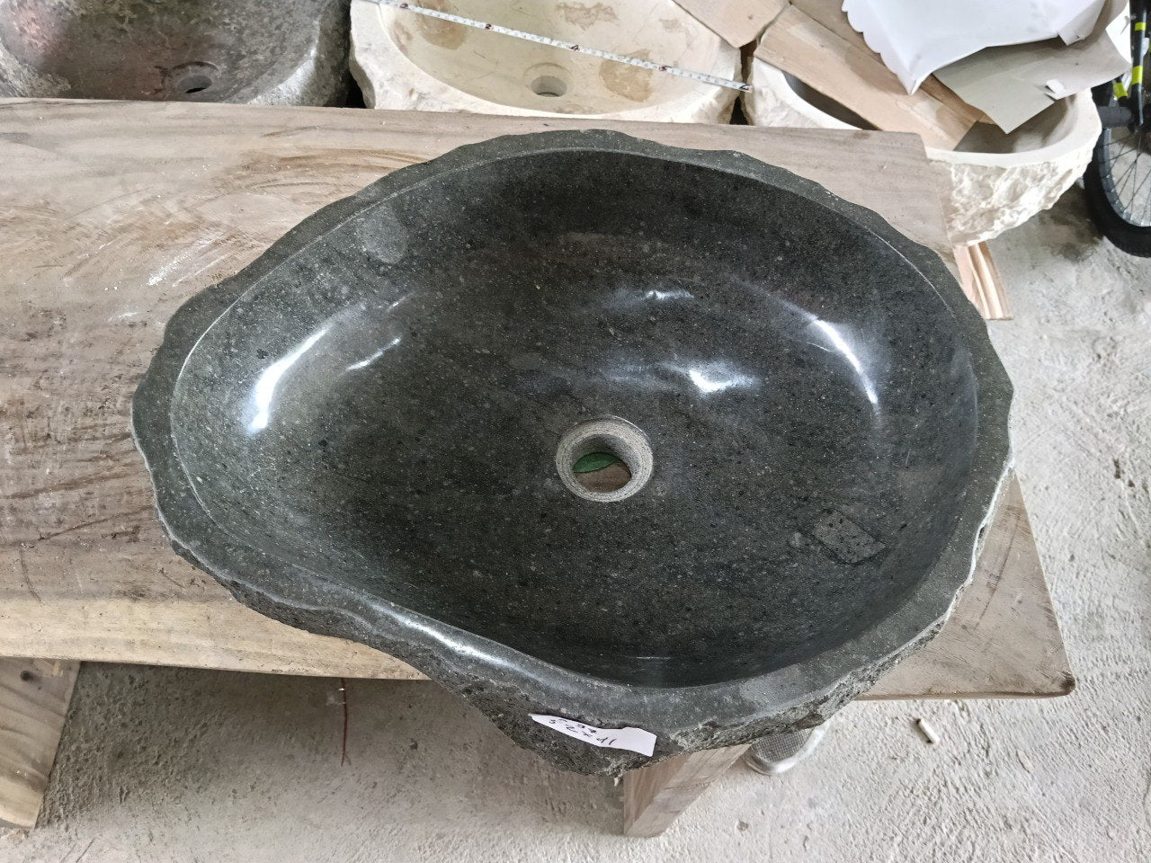 Top view of A97-5241 black andesite stone sink with polished interior and rough chiseled exterior, organic oval irregular shape.
