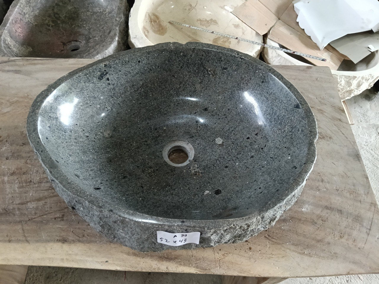 Top view of A99-5243 dark gray andesite stone sink with polished interior and rough chiseled exterior, organic round-oval shape.
